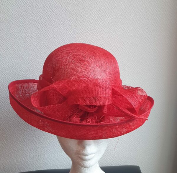 Chapeau de cérémonie large bord de couleur rouge 100% SINAMAY. Les réglages de ce couvre-chef se réalisent soigneusement à l'intérieur par cordon de serrage.