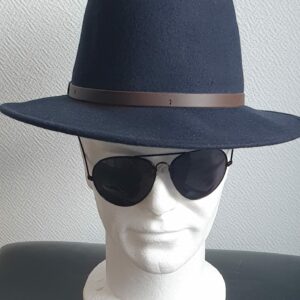 Chapeau feutré laine en bleu cobalt large bord sublimisé par un remarquable petit galon de cuir marron posé à la base de la calotte. Taille :  55 à 60. Confectionné en Italie. Prix : 35.95€.