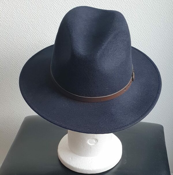 Chapeau feutré laine en bleu cobalt large bord sublimisé par un remarquable petit galon de cuir marron posé à la base de la calotte. Confectionné en Italie.