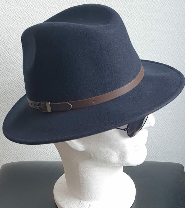 Chapeau feutré laine en bleu cobalt large bord sublimisé par un remarquable petit galon de cuir marron posé à la base de la calotte. Confectionné en Italie.