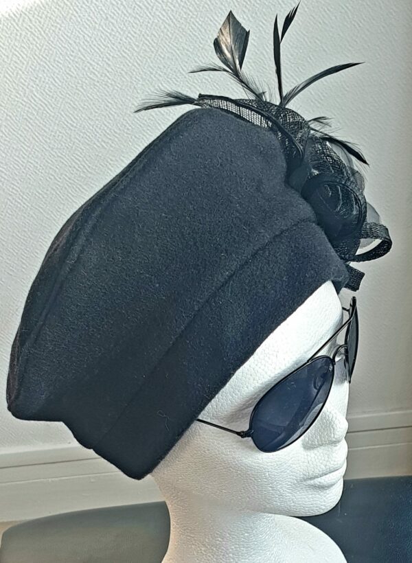 Chapeau de cérémonie en laine style béret. Sa couleur est d'un bleu indigo très original. Un ornement floral est soigneusement disposé sur la coiffe. Disponibilité en série limité.