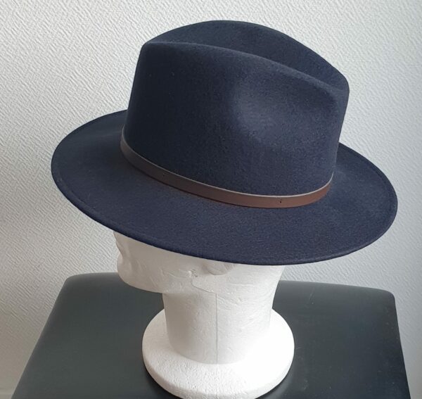 Chapeau feutré laine en bleu cobalt large bord sublimisé par un remarquable petit galon de cuir marron posé à la base de la calotte. Confectionné en Italie.