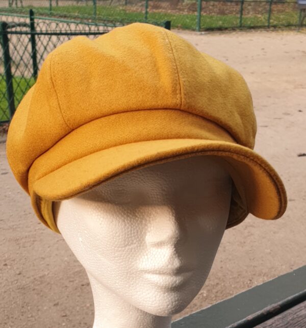 1.1 Gavroche d'hiver en tissu laine mélangée sur une couleur originale jaune vénitien. Réglable à l'arrière par une bande élastique. . Entièrement doublé.  Taille unique. Fabriqué en Chine. Prix :19.95€