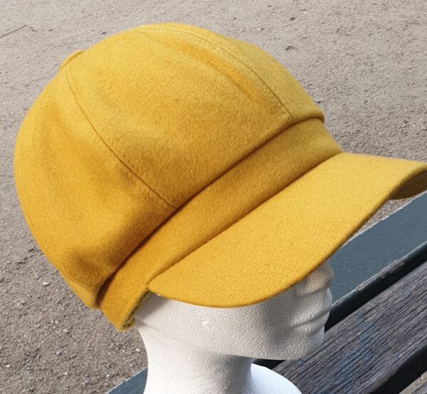 1.3Gavroche d'hiver en tissu laine mélangée sur une couleur originale jaune vénitien. Réglable à l'arrière par une bande élastique. . Entièrement doublé.  Taille unique. Fabriqué en Chine. Prix :19.95€