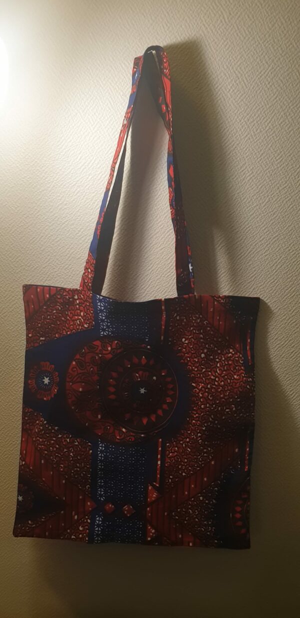 4.4Tote-bag avec d'harmonieuses figures imprimées sur un fond de couleurs bleu-rouge. Dimension 41x38. Création Anjero.