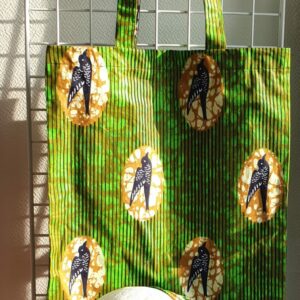 8.1Tote-bag en tissu Wax sur une décoration évoquant des oiseaux en équilibre sur les branches, assorti d'un même bandeau. Dimension : 38cm sur 41cm. Confectionné par Anjero Création. Prix : 26€.